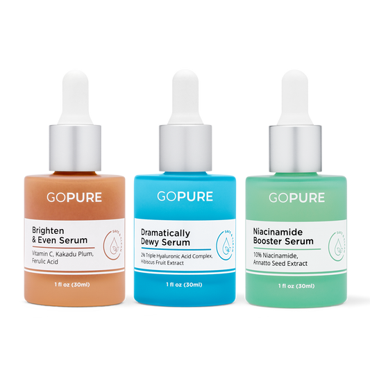 Image of three GoPure serum bottles: a peach-colored 'Brighten & Even Serum' with ingredients like Vitamin C and Ferulic Acid, a blue 'Dramatically Dewy Serum' with ingredients like Hyaluronic Acid, and a green 'Niacinamide Booster Serum' with ingredients like Niacinamide and Annatto Seed Extract.