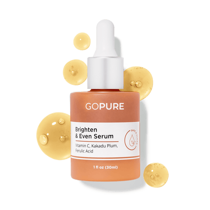  1 fl oz. Peach-colored bottle of GoPure Brighten & Even Serum with white dropper, surrounded by golden yellow serum droplets. Ingredients contain Vitamin C, Kakadu Plum and Ferulic Acid.