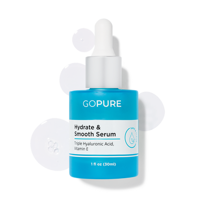 GoPure’s Hydrate & Smooth Serum in a blue bottle with white dropper displayed with serum drops around it. Ingredients include Triple Hyaluronic Acid and Vitamin E. 1 fl oz.